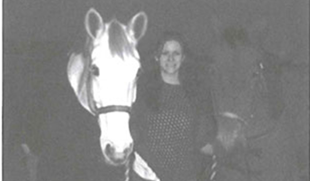 black and white photo of a woman and two horses 